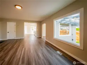 FROM THE HUGE LIVING ROOM INTO THE DINING/DEN/OFFICE AREA AND KITCHEN