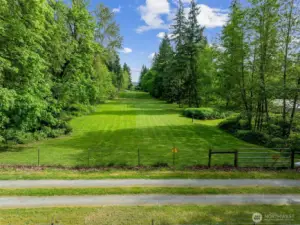 Behind the stables is this beautiful pasture ready for your horses! It extends from fence to fence pictured here.
