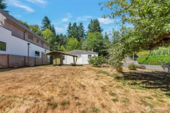 Large fenced yard with fruit trees and garden space