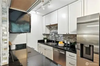 Stunning new white kitchen with slab granite countertops & stainless-steel appliances plus eating bar.