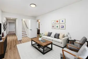 Large family room at the bottom of the stairs could be walled off as a sixth bedroom! The hallway to the left goes to the kitchen and family room, and the door to the right goes to a hallway, full bathroom with laundry, and a bedroom. Virtually staged.