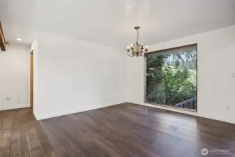 This large picture view window of the land, is the dinning room area, with sweeping views of the landscape and large deck area. Notice the stairs to the garage and shop area.