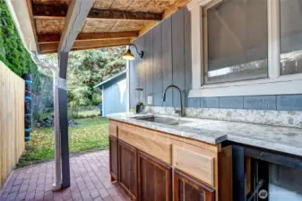 Outdoor kitchen behind detached 2 car garage