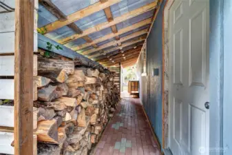 Covered wood storage behind detached 2 car garage