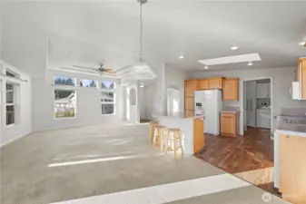 Spotlessly maintained great room with open-concept living and dining, filled with natural light from large windows and a skylight.