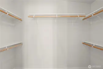 A spacious master closet with built-in shelving provides plenty of room to organize clothing, shoes, and accessories with ease.