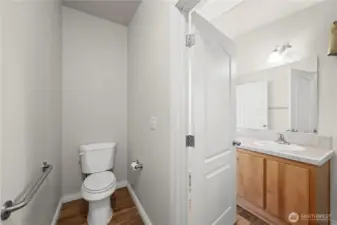 The master bathroom includes a private restroom area, complete with a door and an assist bar on the wall if needed, combining privacy and convenience.