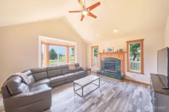Spacious living room is warm and inviting due to the south facing windows and propane stove