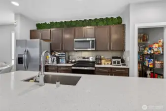 Well-appointed kitchen with stainless steel refrigerator, upper cabinetry, and abundant storage