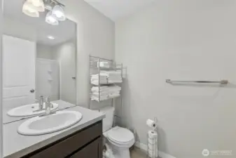 Pristine first-floor bathroom with modern vanity, clean tilework, and quality fixtures and roll-in shower