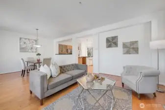 This beautifully connected living and dining area offers an effortless blend of open-concept spaces, creating a bright and welcoming environment for everyday living and entertaining. The living room flows seamlessly into the dining area and kitchen, allowing natural light to move freely throughout the home. Large windows frame scenic mountain views, adding a stunning backdrop to the warm, contemporary design. Thoughtful finishes, comfortable seating areas, and a cohesive layout make this an inviting space to gather and unwind.