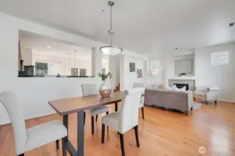 Open-concept living and dining area offers a bright, cohesive flow that brings the entire main level together. The dining space sits comfortably between the kitchen and living room, creating an effortless connection for everyday living and entertaining. Warm natural light fills the room through multiple windows, highlighting the contemporary finishes, inviting fireplace, and clean, modern design. It’s a beautifully integrated space that feels both spacious and welcoming.