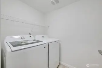 The lower level includes a spacious laundry room equipped with a brand-new washer and dryer that stay with the home. This functional space offers plenty of room for organization and everyday convenience, making household tasks simple and efficient.