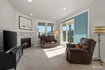 Cozy living room with gas fireplace and sliding glass door to the wrap-around balcony
