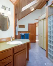 The shower is behind the glass blocks and the laundry is just beyond the blue towels.