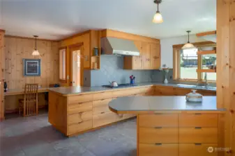 Spacious kitchen in the main home with tile counters and floors.