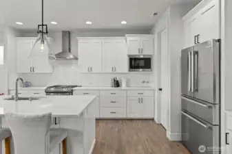 Stainless steel appliances and a walk-in pantry bring both luxury and practicality to this beautifully designed culinary space.