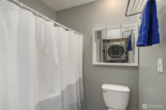 Full bathroom with additional space for washer and dryer.