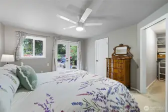 Primary bedroom has French doors with access to the back patio. Walk in closet is to the right.