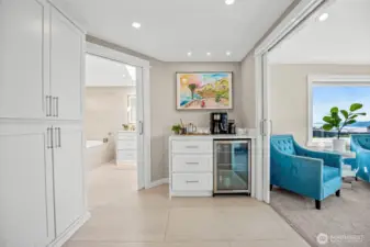 The top of the stairs welcomes you to the primary suite that is more like a private oasis! Yes, that is a beverage fridge and coffee station just for you!