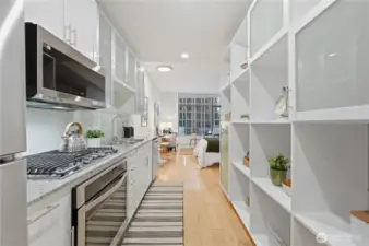 Stunning kitchen area with everything you need; gas cooktop, built in-oven, microwave & dishwasher & plus wonderful size refrigerator.  Plenty of kitchen cabinet storage plus the built-in shelving for more space!