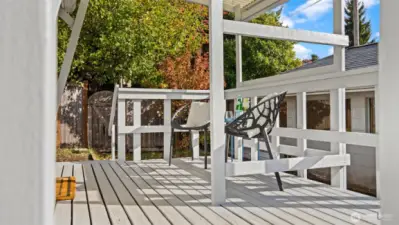 Another angle of the back deck and garage shows off just how private this property feels. The mature trees along the edge create a natural green backdrop - perfect for relaxing outdoors or hosting a quiet evening under the canopy.