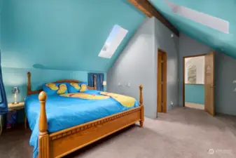 Upper level main bedroom with vaulted ceiling, skylights and a 3/4 bath.