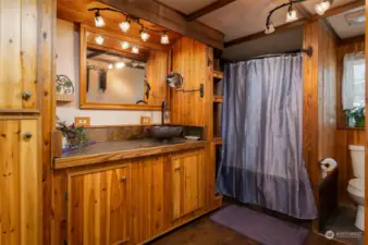 How about this primary bathroom? Vessel sink, slate countertop & floor, custom lighting & attractive wood cabinetry