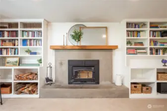 Wood stove is flanked by custom built-in shelving