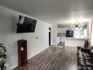 View of living room, to the left is hallway to 2 bedrooms and bathroom.  Kitchen in view.