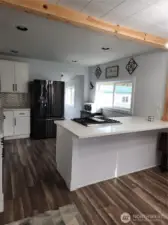 Open concept kitchen with beautiful granite countertops, gas range, and modern backsplash.