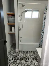 Storage space to the left of the tub/shower unit.