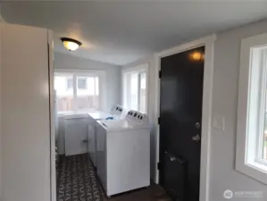Utility room off the kitchen, washer and dryer and installed storage stays.  Notice the doggy door for convenience, if you have pets.