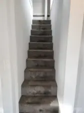 Upon entering the utility room, directly to the left are the stairs to the upstairs bonus/bedroom space.