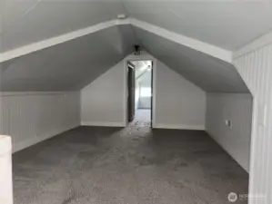 At the top of the stairs is this spacious bonus room you could make into a media or TV room.  Bedroom 3 is in view through the doorway.