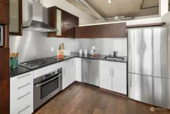 This sleek kitchen boasts a gas cooktop and premium stainless-steel appliances.