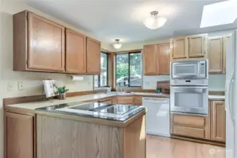 A bright eat-in kitchen offers a double oven, large pantry, corner window and deck slider.