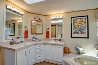 Main bathroom is spacious and has lots of natural light with windows and skylight overhead.