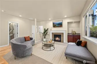 This cozy secondary living room in Puyallup’s LaGrande Station community blends warmth, style, and smart layout. The elegant gas fireplace anchors the space, while large windows bring in light and greenbelt views. This angle showcases direct access to the main-level half bath and nearby second primary suite, ideal for multigenerational living or guest privacy. Neutral tones, plush carpet, and built-in cabinetry make this room perfect for relaxing or entertaining in one of Puyallup, WA’s most desirable neighborhoods.