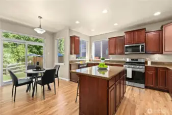 Located in the heart of Puyallup’s LaGrande Station community, this beautifully appointed kitchen features warm hardwood floors, granite countertops, rich cabinetry, and a center island with bar seating. Stainless steel appliances and a gas range add modern functionality, while large windows and a sliding glass door offer abundant natural light and scenic greenbelt views. The adjacent breakfast nook is ideal for casual meals, making this space the perfect balance of comfort, style, and practicality in one of Puyallup, WA’s most desirable neighborhoods.