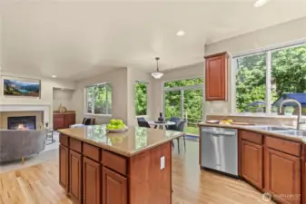 This beautiful kitchen in Puyallup’s LaGrande Station offers stunning greenbelt views from every angle, including the sink, dining area, and adjoining living room. Granite countertops, a spacious island, stainless steel appliances, and ample cabinet storage make it as functional as it is attractive. The open-concept layout flows effortlessly into the casual dining nook and cozy living room with a gas fireplace, ideal for entertaining or everyday comfort. Expansive windows and a sliding glass door bring in natural light and frame the lush backyard scenery, making this kitchen the true centerpiece of the home.