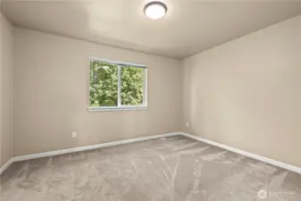This peaceful upstairs bedroom in Puyallup’s LaGrande Station community offers a serene retreat with a window that overlooks the private, wooded greenbelt. The room features soft neutral walls, fresh carpeting, and a clean layout ideal for use as a guest room, nursery, or home office. Natural light pours in through the window, highlighting the beautiful outdoor scenery and creating a warm, calming atmosphere. Enjoy comfort and quiet in one of Puyallup, WA’s most desirable neighborhoods.