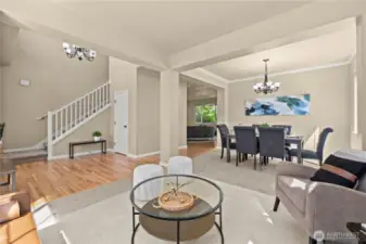 This thoughtfully designed open-concept main floor in Puyallup’s LaGrande Station community offers seamless flow between the formal living room, dining area, and entryway. Rich hardwood floors complement soft carpeted zones, while oversized windows bring in natural light and highlight the welcoming layout. Crown molding, modern lighting, and architectural columns add elegance and structure to the space. The open staircase and multiple seating areas make it easy to entertain or relax in comfort. Located near top schools, transit, and shopping, this layout offers both function and style in one of Puyallup, WA’s most desirable neighborhoods.
