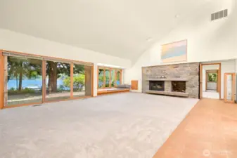 Living room with vaulted ceilings & expansive wall of windows for endless lake views