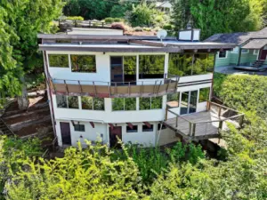 Back of home with lots of windows and 2 view decks.