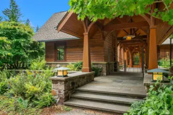 Main entry with custom crafted wooden arches lining the covered breezeway