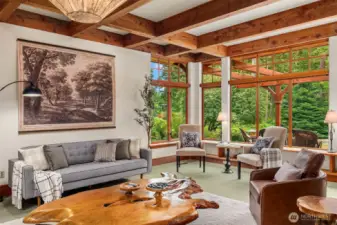 Box beam ceilings plus walls of wood cased windows enhance the spacious living room