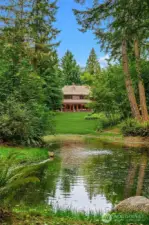 Views of the home from beyond the meadow and across the pond