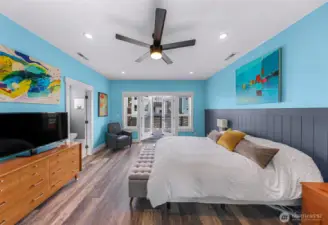 Large primary bedroom with French doors to back yard balcony.
