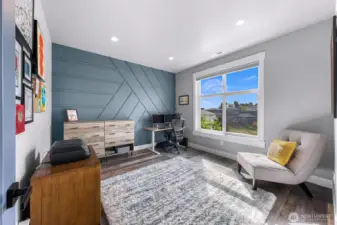 Second upstairs bedroom with accent wall and occasional mountain views from the south facing window.